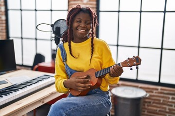 African american woman musician playing ukulele at music studio