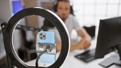 Young hispanic man reporter recording video on radio show at radio studio