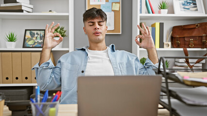 Attractive young hispanic man working hard at a business job, finding balance by doing a calm...