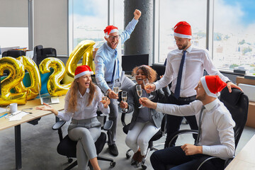 Business people are celebrating holiday in modern office drinking champagne and having fun in coworking. Merry Christmas and Happy New Year 2024