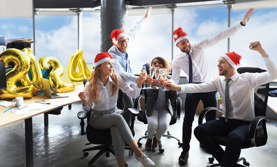 Business people are celebrating holiday in modern office drinking champagne and having fun in coworking. Merry Christmas and Happy New Year 2024 - obrazy, fototapety, plakaty