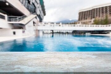 Empty table on swimming pool background in tropical resort