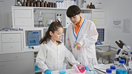 Two serious-faced scientist partners standing together, speaking about medical research analysis in...