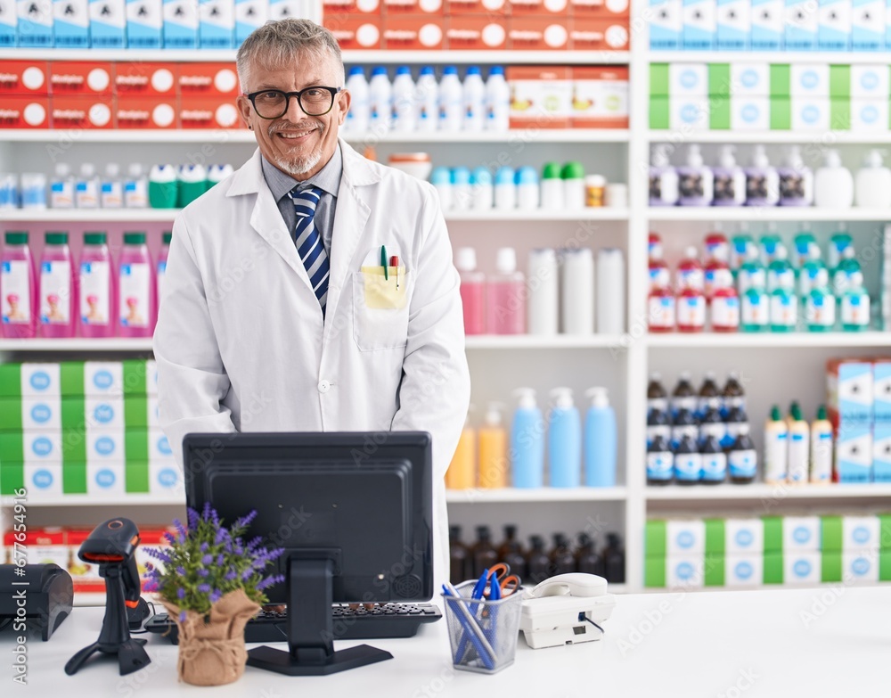 Wall mural Middle age grey-haired man pharmacist smiling confident using computer at laboratory