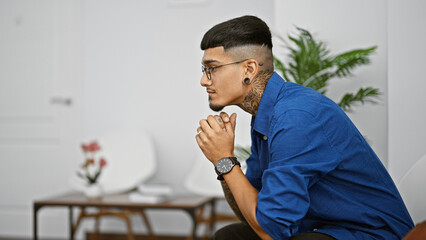 Young latin man sitting on chair at waiting room