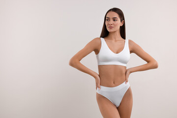 Obraz premium Young woman in stylish bikini on white background. Space for text