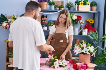 Man and woman customer asking to florist for bouquet of flowers at flower shop
