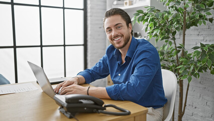 Young hispanic man business worker using laptop working at the office