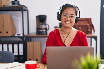 Young chinese woman call center agent smiling confident working at office