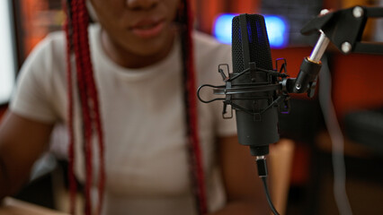 Beautiful african american woman musician passionately singing song in music studio