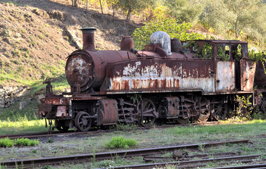 Obraz premium Abandoned, aged, rusty steam locomotive, pieces of track from a closed line