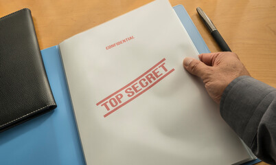 Hand of a man opening a top secret file folder