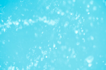 Defocus blurred transparent blue colored clear calm water surface texture with splashes reflection. Trendy abstract nature background. Water waves in sunlight with copy space. Blue watercolor shine.