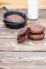 Fresh homemade chocolate chip cookies in an iron skillet on a wooden rustic background