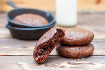 Fresh homemade chocolate chip cookies in an iron skillet on a wooden rustic background