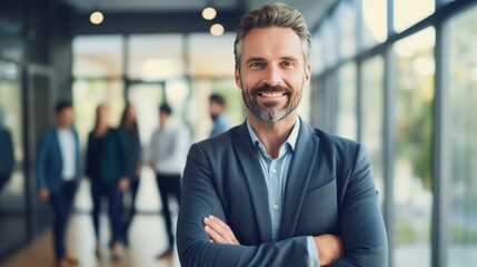 Portrait of Smiling confident business leader looking at camera and standing in an office with blurred background teamwork