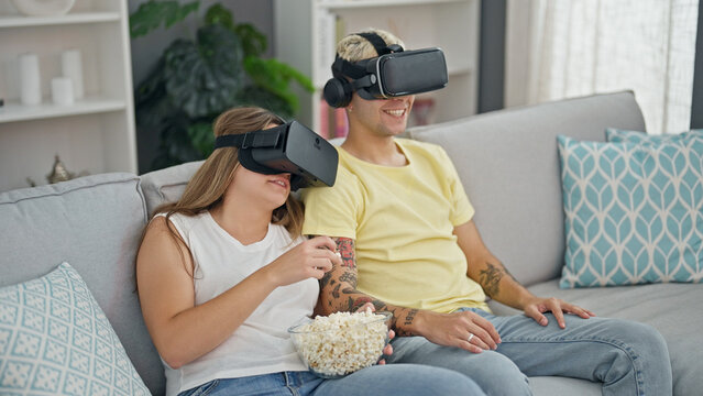 Beautiful couple watching movie on virtual reality glasses at home