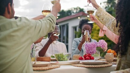 Celebration party dinner at home yard. Group of diverse multicultural people, friends drinking, making toast with white wine and have conversation together. Happiness and joyful wonderful moments. - Powered by Adobe