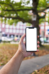Man holding smartphone showing white blank screen at park