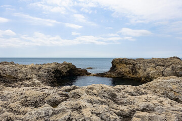 Fototapeta na wymiar Cape Tarkhankut on the Crimean peninsula. The rocky coast of the Dzhangul Reserve in the Crimea. The Black Sea. Turquoise sea water. Rocks and grottoes of Cape Tarkhankut.