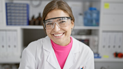 Charming young hispanic woman scientist, beaming with confidence and beauty, working in the lab,...