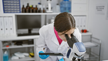 Captivating tale of a young, beautiful hispanic woman scientist, mastering the microscope and penning discoveries on a touchpad in her vibrant lab