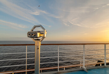 Jumelles sur le pont d'un navire de croisière en navigation en mer avec un coucher de soleil. 