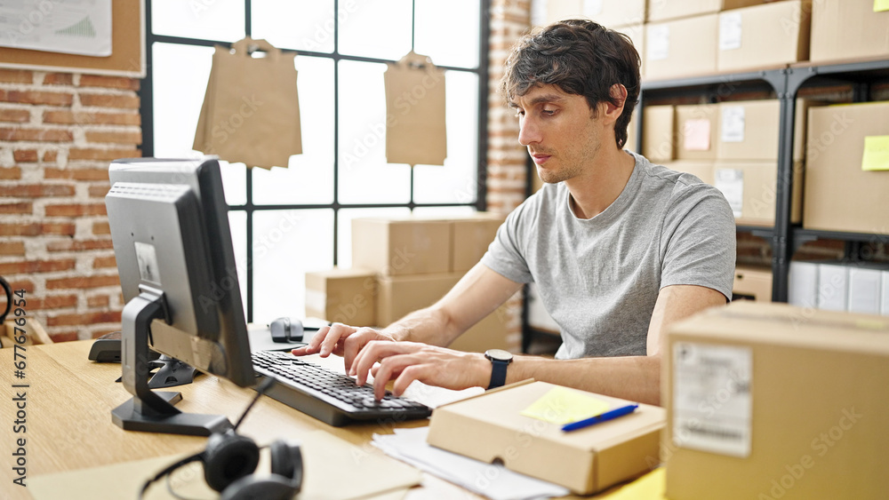 Sticker Young hispanic man ecommerce business worker typing on computer with serious face at office