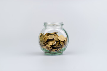 Saving coins in a glass jar, coin bank, financial investments, income, wages, mutual funds, cash flow, financial growth, investors