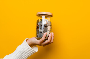 Saving coins in a glass jar, coin bank, financial investments, income, wages, mutual funds, cash...