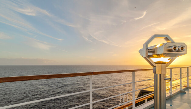Jumelles sur le pont d'un navire de croisi&egrave;re en navigation en mer avec un coucher de soleil. 