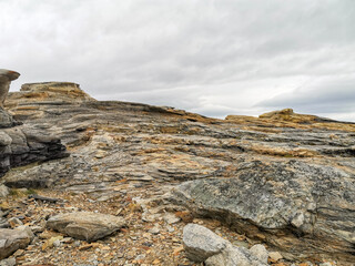 The shore of red stones next to the rocks are Two Brothers on the Fishing Peninsula. The picturesque shore of the harsh Barents Sea. The North of Russia. The Kola Peninsula. The Arctic