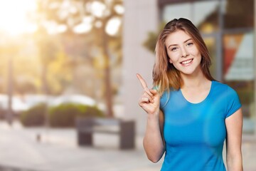 Young beauty woman pointing to background.