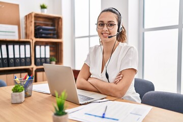 Young hispanic woman wearing call center agent headset at the office happy face smiling with...