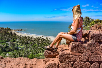 A girl on the background of the view from Forte Chapora. In the background is a view of the beaches of Anjuna and Vagator in the northern part of Goa. The fort rises high above the Chapora River.