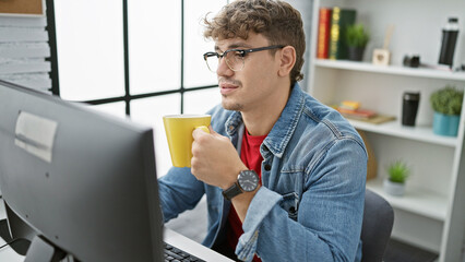 Handsome young hispanic man, a relaxed yet focused business professional, deeply engrossed in work,...
