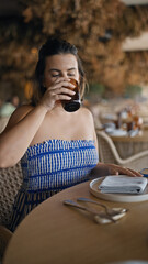 Young hispanic woman drinking a glass of water at the restaurant