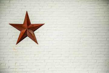 Red star on white brick wall 
