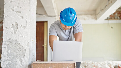  architect using laptop with serious expression at construction site