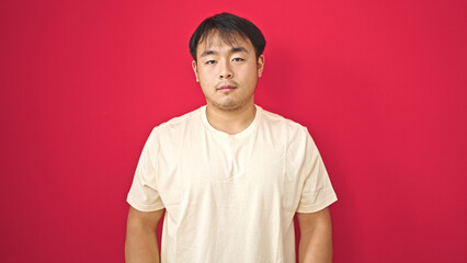  standing with serious expression over isolated red background