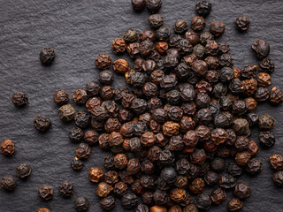 black pepper seeds on the surface of a black stone