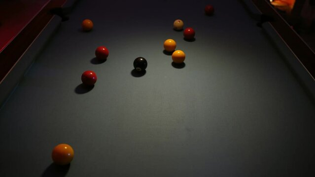 Overhead view of breaking racked pool balls in eight-ball formation on green billiards table for start to play