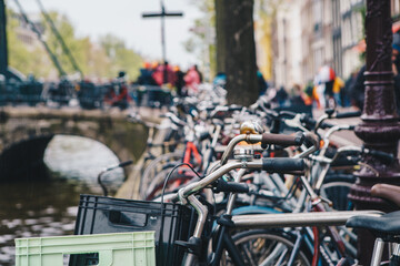 Many old bicycles parked near the canal in center of Amsterdam. Traditional Dutch urban transport