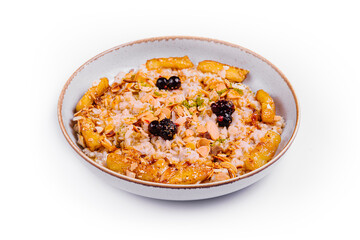 Muesli with dried fruits and milk in ceramic bowl