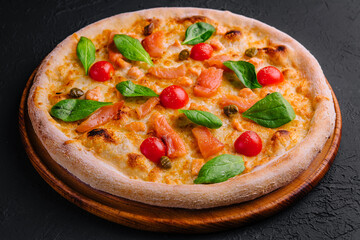 Tasty seafood pizza with tomatoes, cheese, salmon and basil