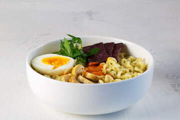 bowl of soup. A bowl of Korean soup with mushrooms and green onions. Asian noodle soup, ramen with meat, vegetables and eggs in white bowl on the white background. Copy space.