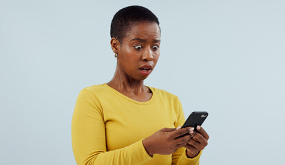 Black woman, phone and shocking news on social media, terrifying or online against a studio...