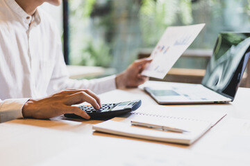 Businessman calculates budget, income and expenses with a calculator, financial planning and accounting.