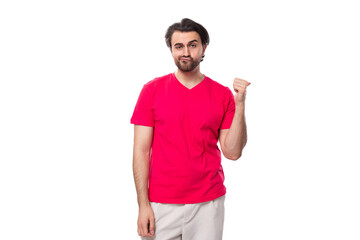 young pleasant slender brunette man with a cool hairstyle is dressed in a red t-shirt with a mock-up for printing on fabric