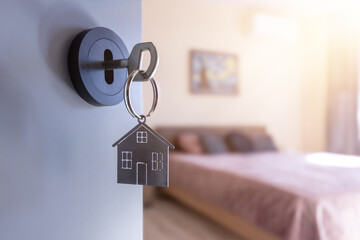 Open door to a new home with key and home shaped keychain. Mortgage, investment, real estate, property and new home concept